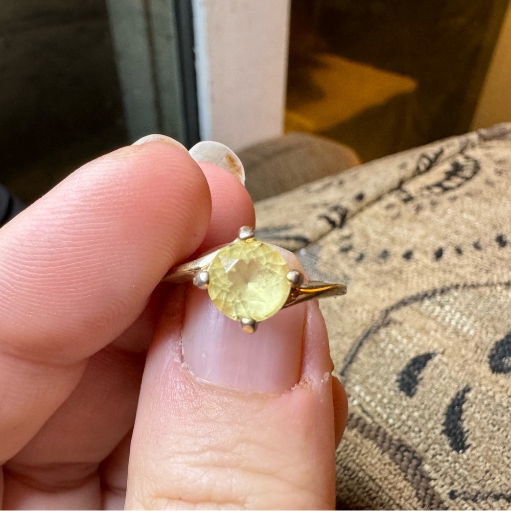Gold ring with pale yellow faceted stone.